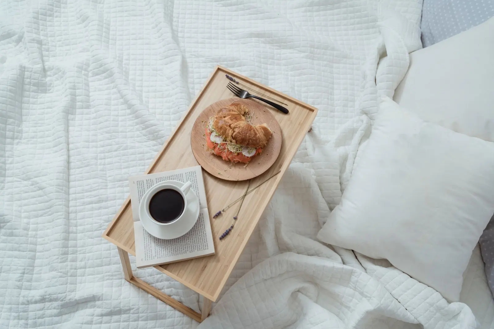 Plateau de petit-déjeuner posé sur un lit fait